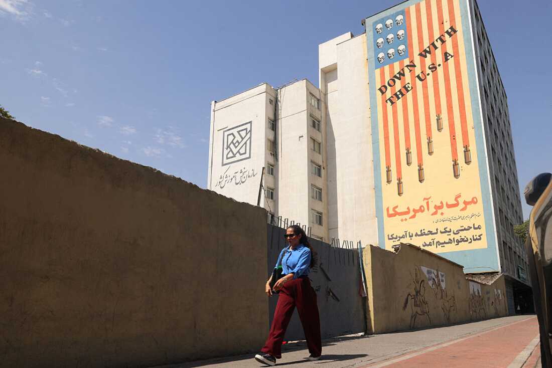 An Iranian woman walks past an anti-U.S. banner in Tehran on Sunday.