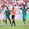 Some players celebrate, and another clutches his head, as players react to FIFA referee Said Martinez when a penalty kick is awarded to Belgium after the VAR review.