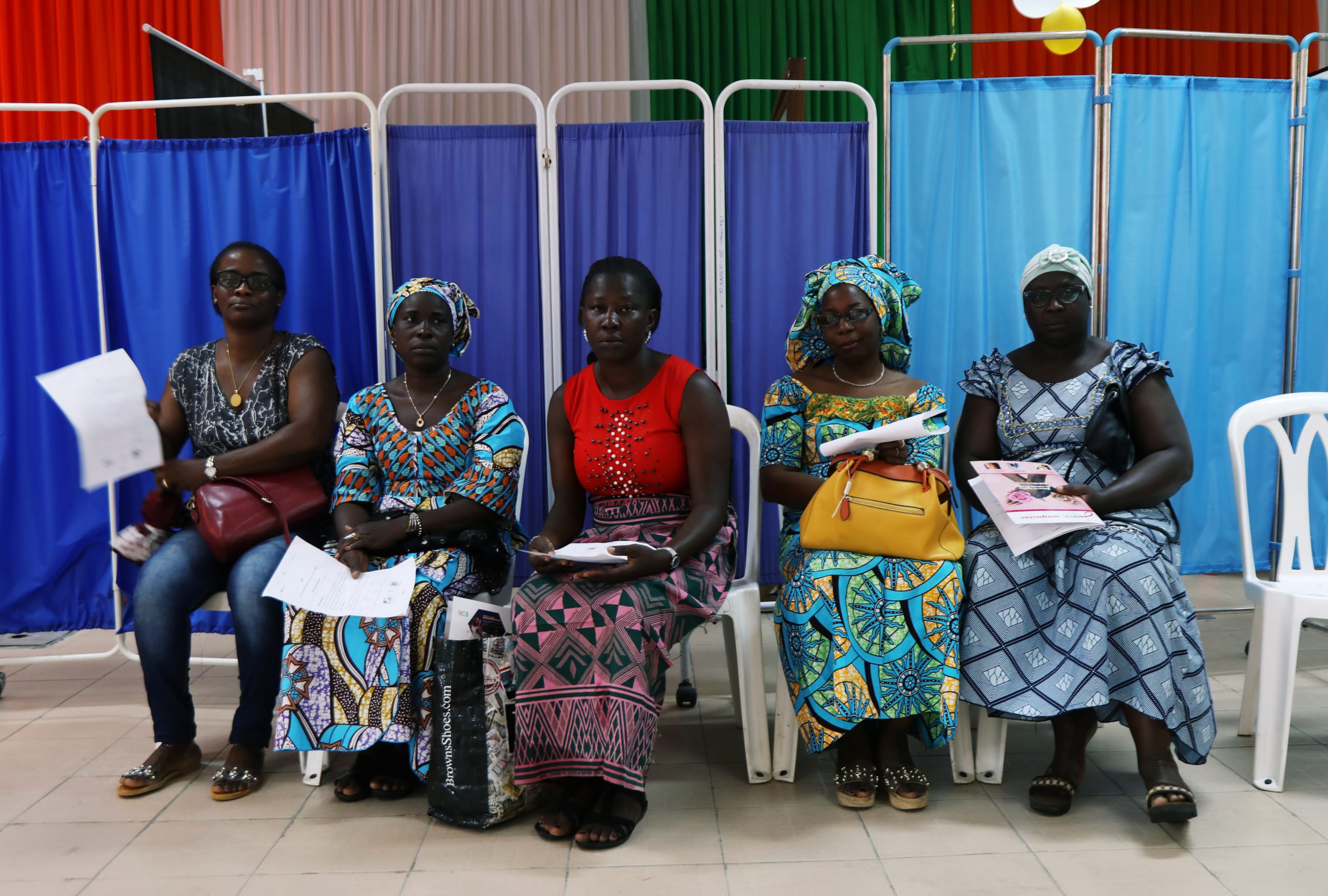 Women sit as they prepare for screenings during a breast cancer prevention campaign, in Abidjan, Ivory Coast, on October 12, 2019.