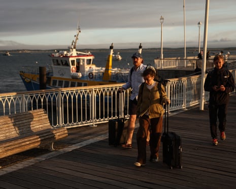 Holidaymakers from Lege-Cap-Ferret carry their belongings along the pier upon their arrival in Arcachon during an evacuation operation of the entire Cap-Ferret peninsula in southwestern France.