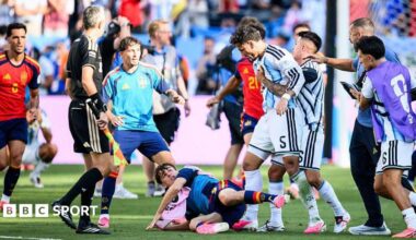 Leandro Parades (fourth right) is pulled away by teammates with a Spain player on the floor at his feet