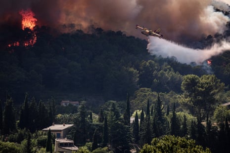 A French Civil Security Canadair CL-415 aircraft sprays water on a forest surrounding Cotignac, southeastern France.