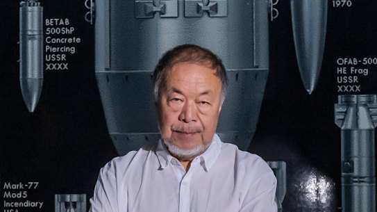 Ai Weiwei poses beside his new work History of Bombs, a 30-metre wide installation built from over a million toy bricks, part of an exihbition and live performance exploring the entwined histories of China and Britain.