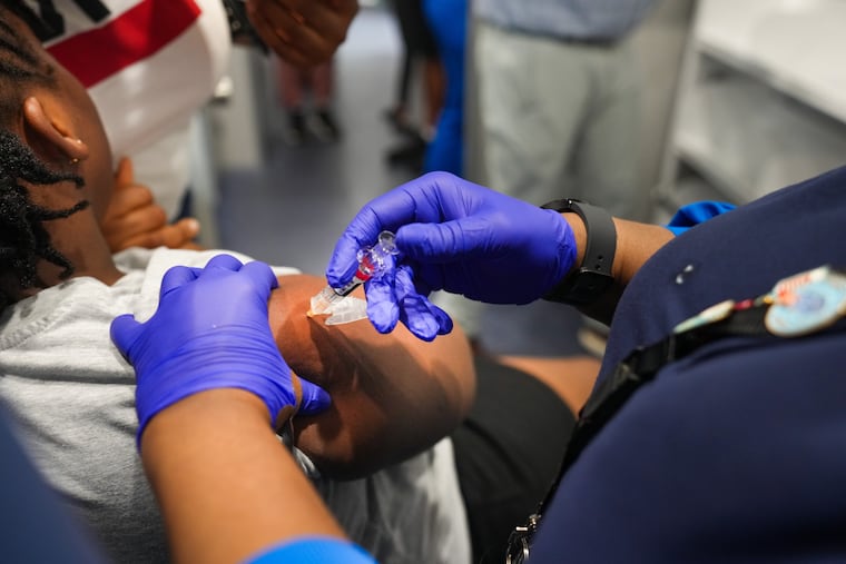 Mia Williams, a registered nurse, vaccinates a 9-year-old girl inside Delaware County Health Department's Wellness on Wheels mobile clinic in Upper Darby.