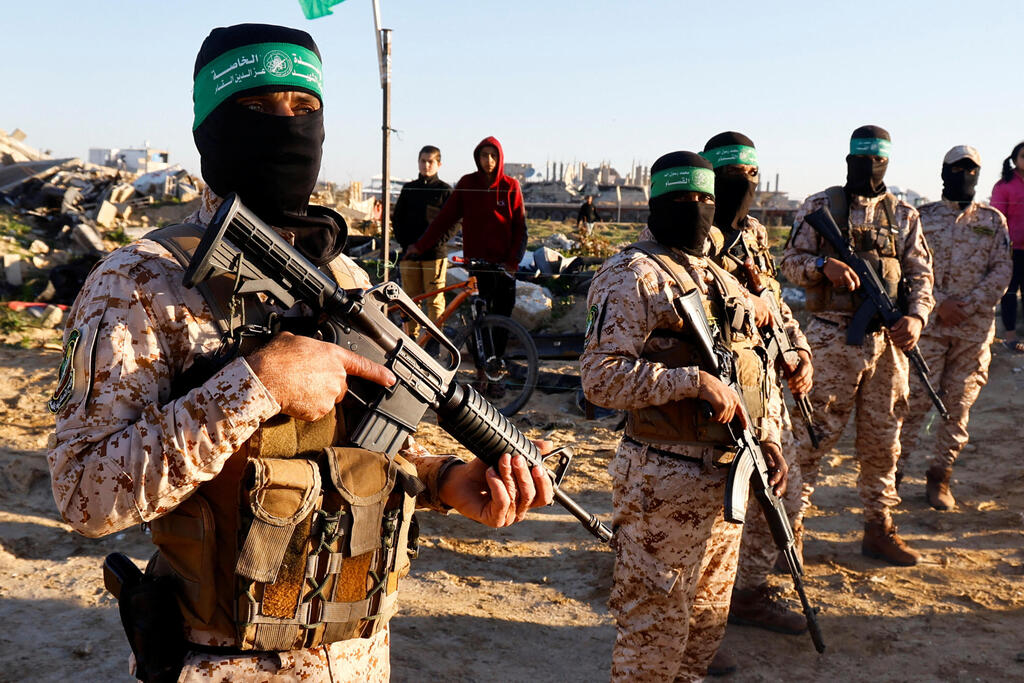 Photo: REUTERS/Hatem Khaled מחבלי חמאס באיזור שחרור החטופים בעזה