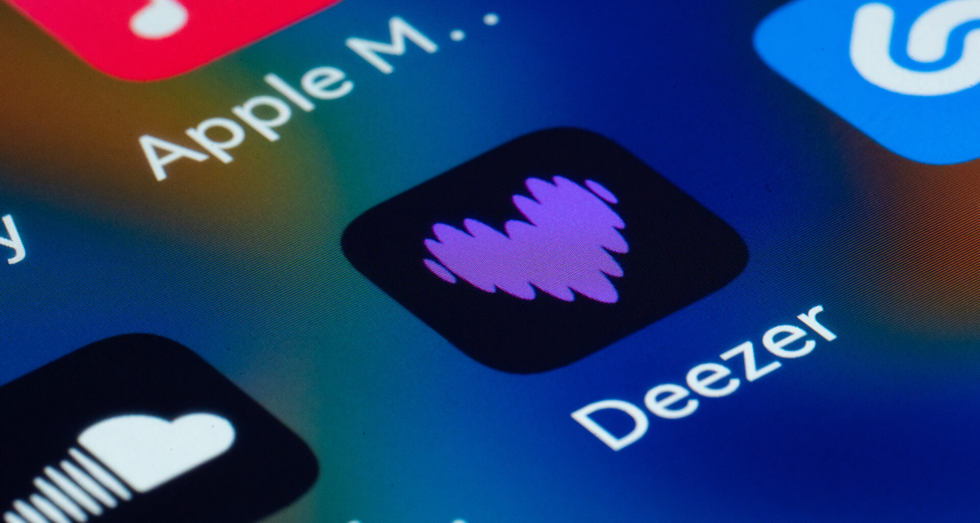 Close-up view of a smartphone screen displaying popular music streaming and audio applications, highlighting Deezer