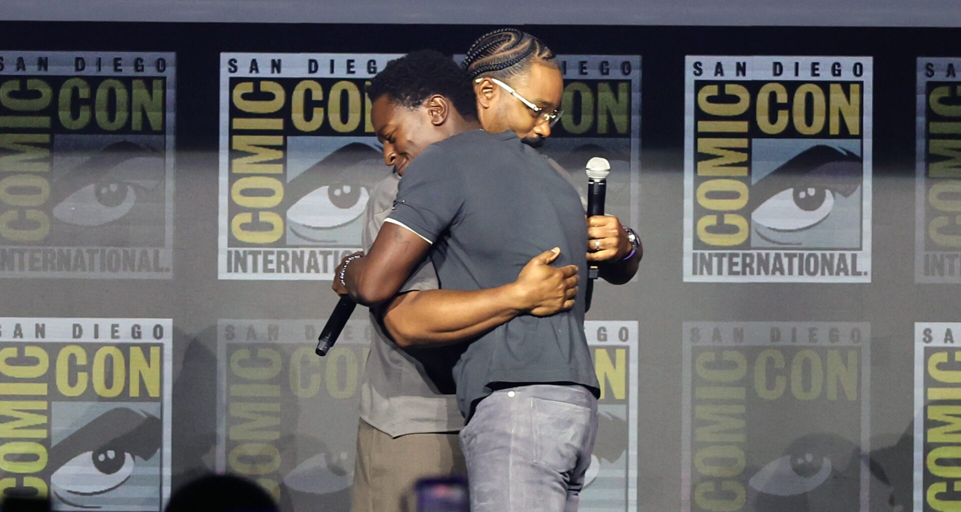 Ryan Coogler hugs David Jonsson on stage during Marvel's Comic-Con panel.