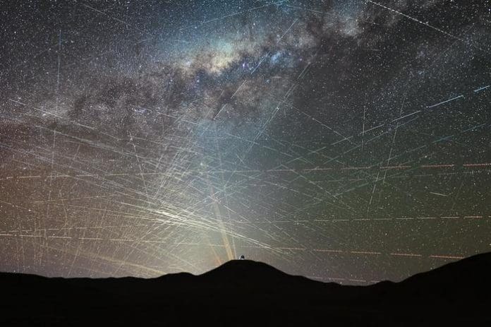 This image shows satellites crossing the night sky above the northern Atacama Desert in Chile, over a period of just one hour. It is a stack of a time-lapse video taken on 15 October 2025 about two hours after sunset. A few streaks are caused by planes, and can be easily identified by their blinking-coloured lights, but most trails are due to satellites. In the foreground we see the dome of ESO’s Extremely Large Telescope (ELT), the world’s largest optical/infrared telescope, currently under construction atop Cerro Armazones. Behind it we see the lasers of ESO’s Very Large Telescope (VLT) at Paranal Observatory, 22 km away from the ELT. Credit F. Kamphues, ESO/M. Kornmesser