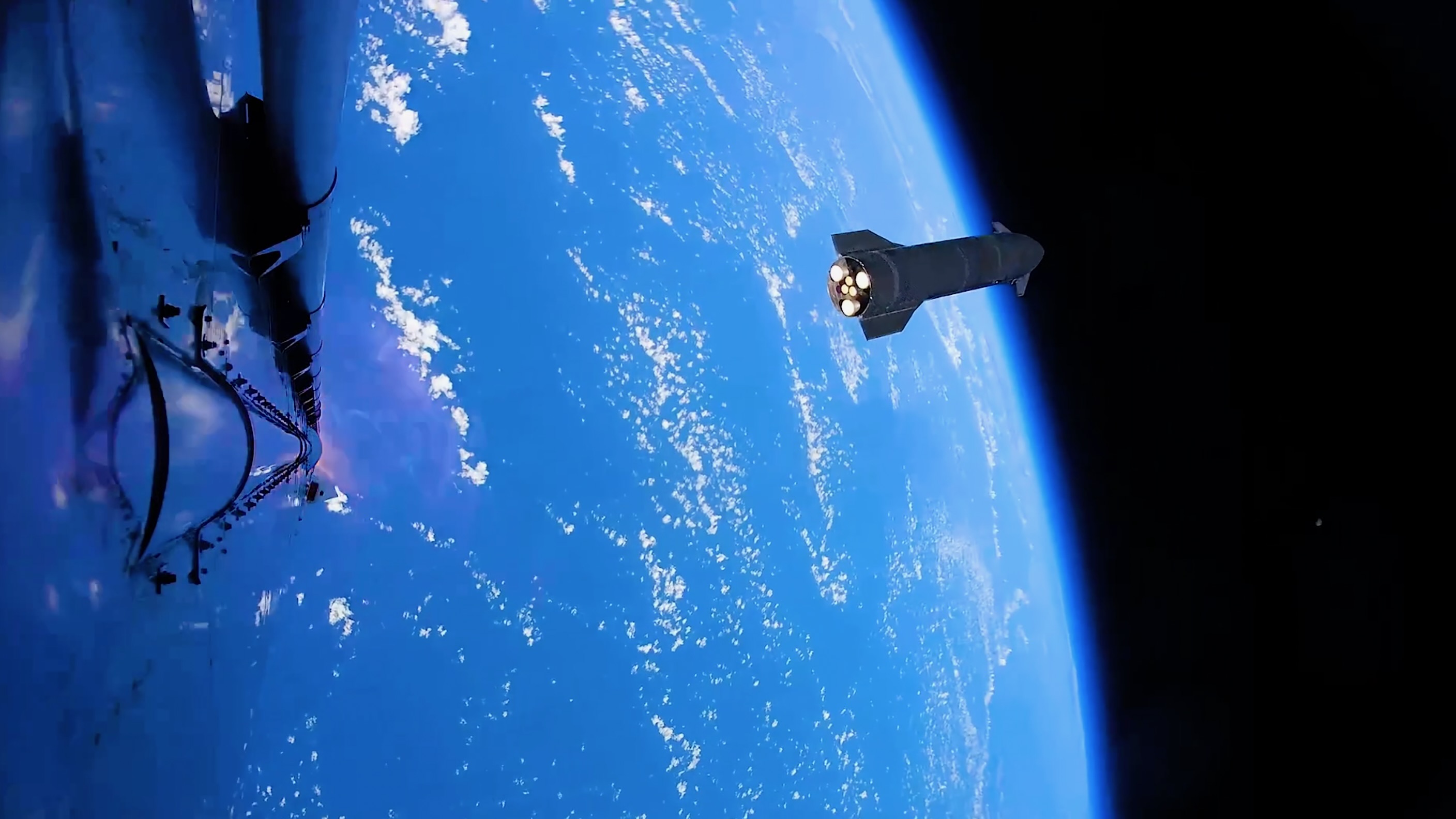 a dark, conical spaceship is seen high above Earth from another spacecraft in space