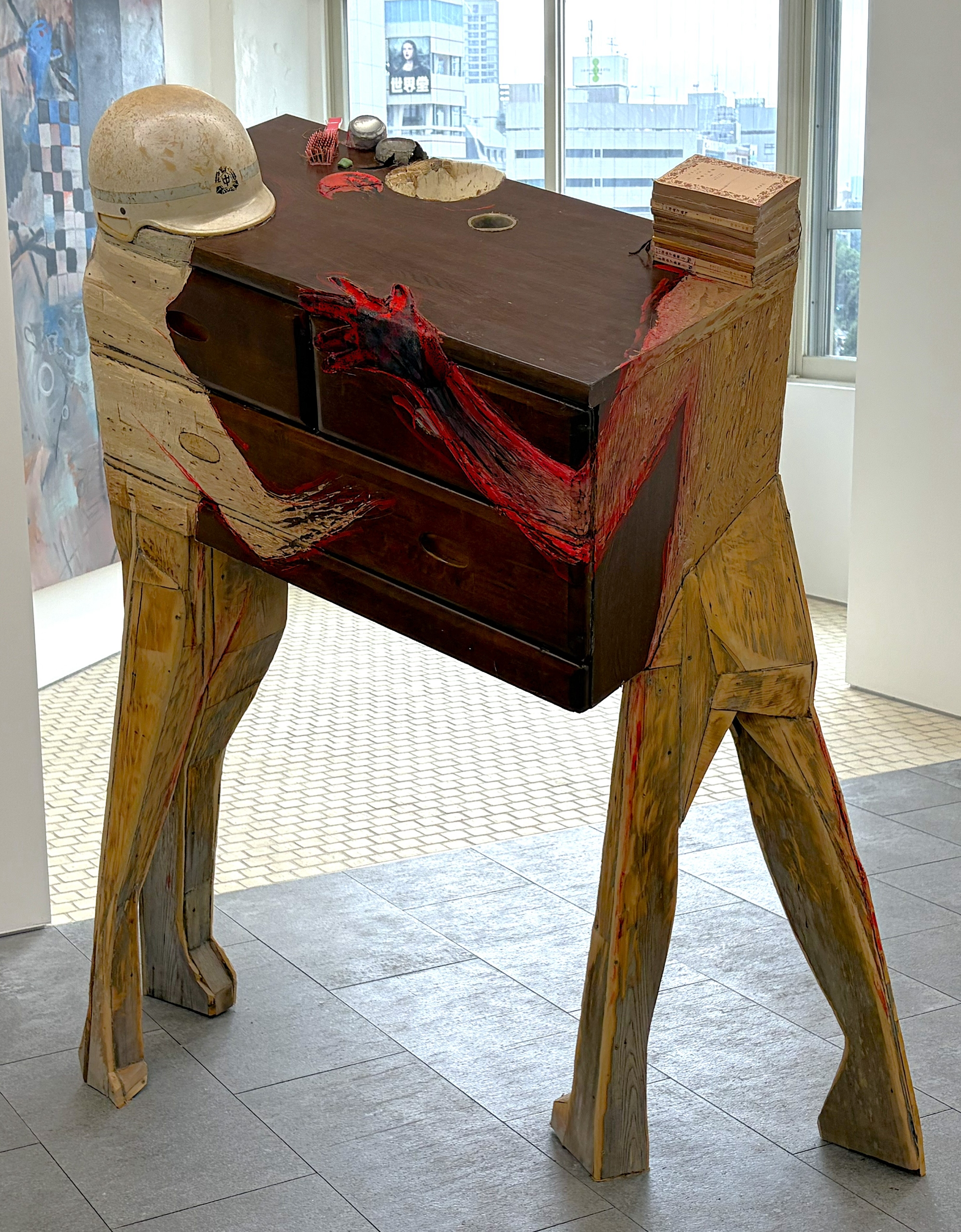 a wooden assemblage sculpture by Fumiaki Aono of two figures carrying furniture