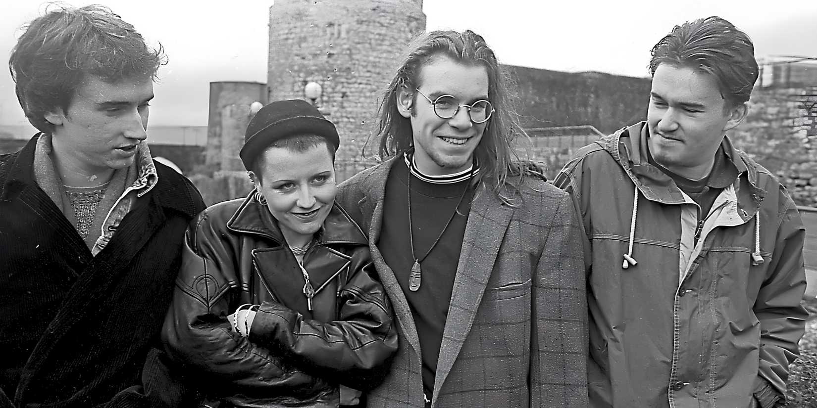 Black and white photo of The Cranberries outside of a castle.