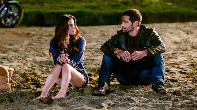 Abby O'Brien (Meghan Ory) and Trace Riley (Jesse Metcalfe) sit together on a beach in Chesapeake Shores