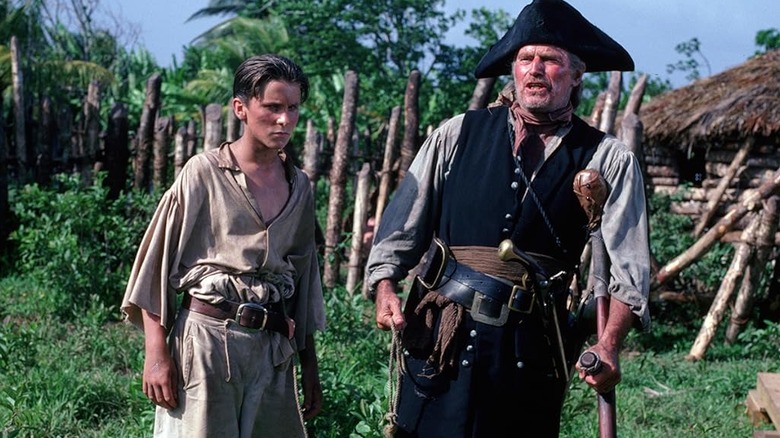 Jim Hawkins standing next to Long John Silver in Treasure Island