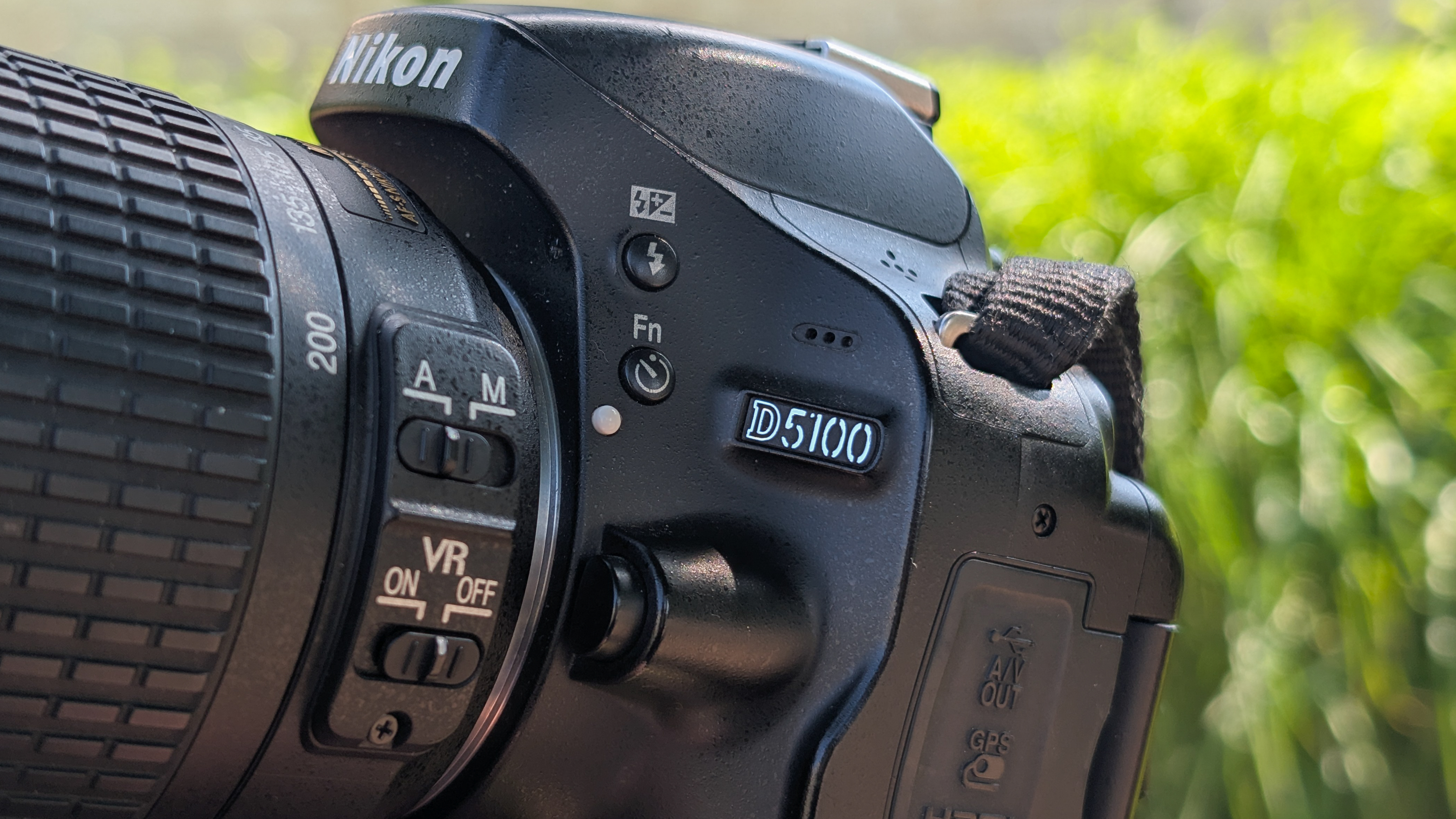 A person holding a Nikon D5100 DSLR camera