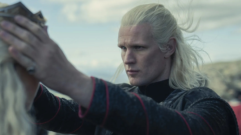 Matt Smith as Daemon placing a crown on Emma D'arcy as Rhaenyra's head outside in House of the Dragon