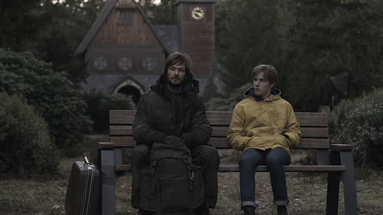 Adult Jonas and teenage Jonas sitting on a bench in 