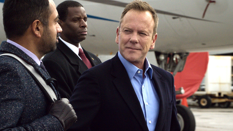 President Tom Kirkman and Seth Wright in suits standing in front of an airplane in Designated Survivor