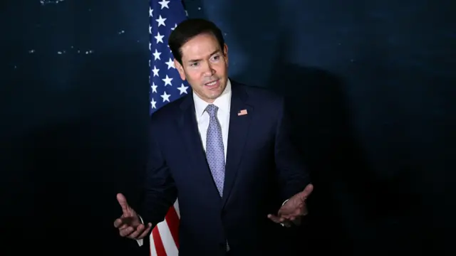 Marco Rubio is pictured wearing a blue suit with his hands out in front