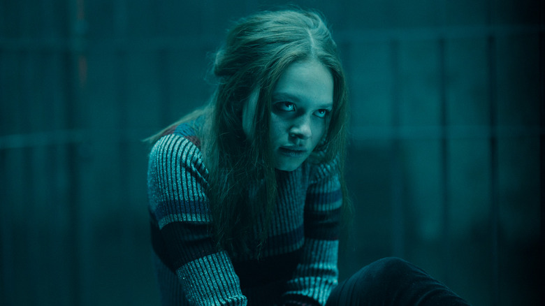 Beatrix glowering in a dark room