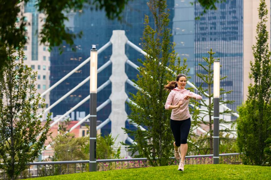 A runner lifts their wrist to check their smart watch to keep track of their workout stats.