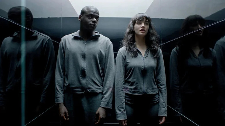 Daniel Kaluuya's Bing and Jessica Brown Findlay's Abi Khan in a narrow hallway on Black Mirror