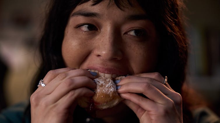 Production image: close-up of Hana eating a donut.