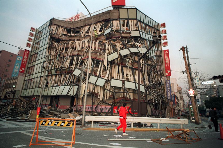 A Kobe resident passes by a central office building on January 18, 1995 that was damaged in an earthquake the previous day.