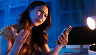 A woman looking angrily at her phone.