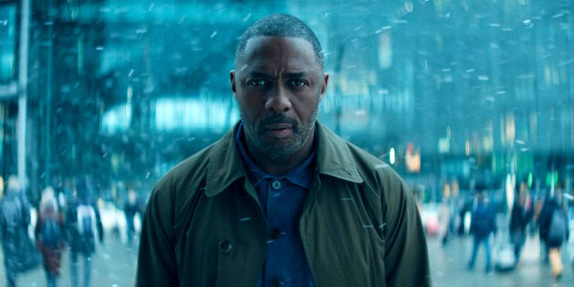 Idris Elba looking toward the camera while standing in a city in Hijack Season 2.