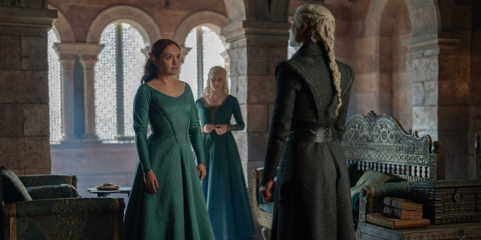 Alicent (Olivia Cooke), Helaena (Phia Saban), and Rhaenyra (Emma D'Arcy) standing in Alicent and Rhaenyra's private chamber in House of the Dragon Season 3, Episode 2.