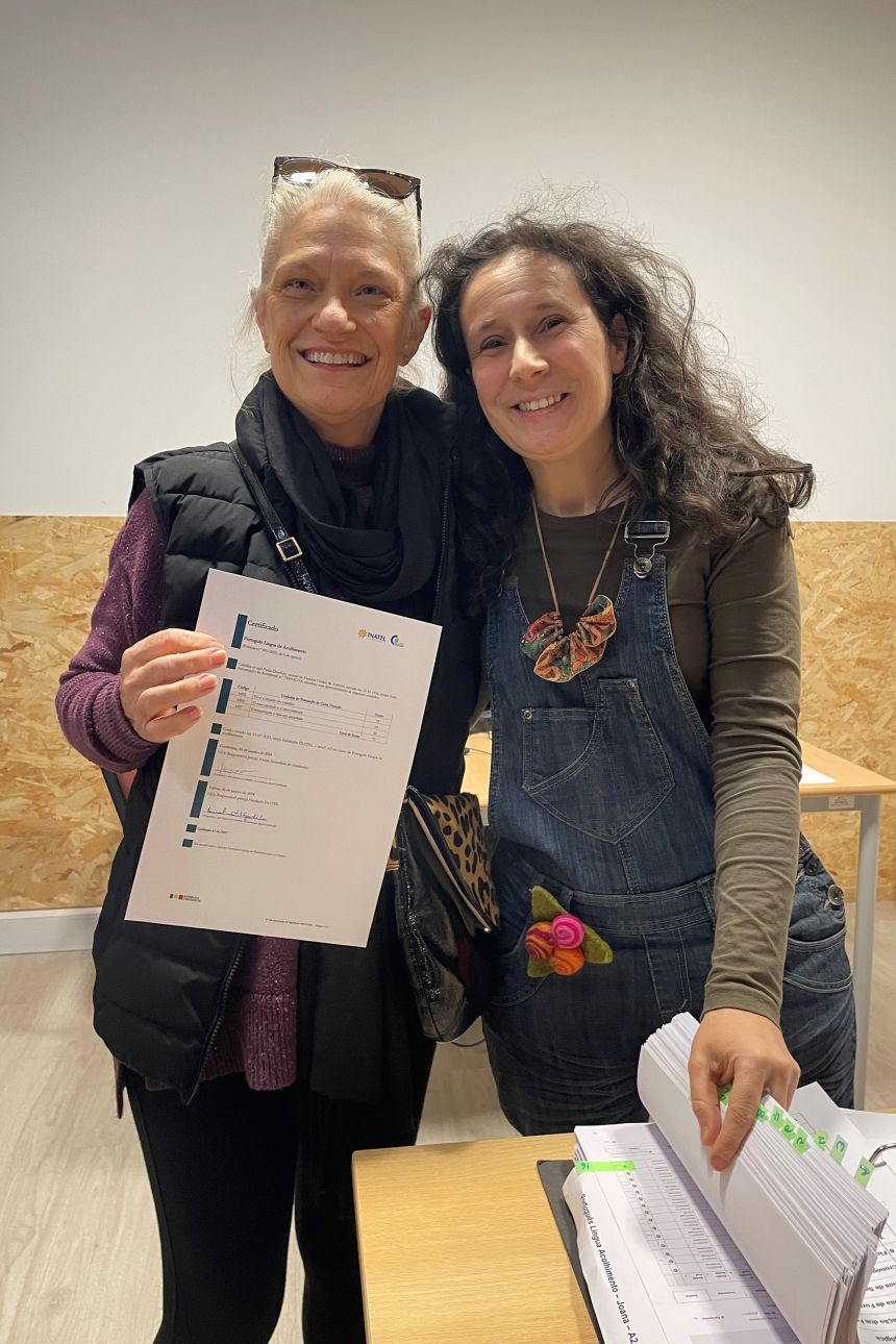 Paula is seen receiving her certificate of A2 level Portuguese proficiency, which is required for permanent residency or citizenship.