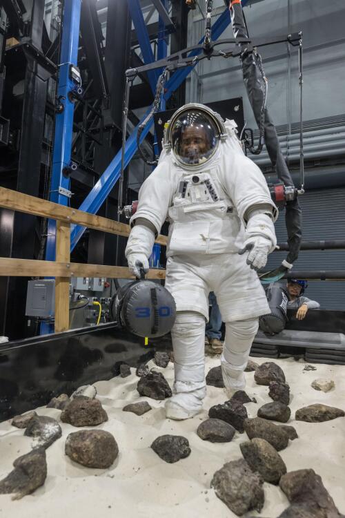 Victor Glover dodging rocks and carrying a bag during moonwalk simulation