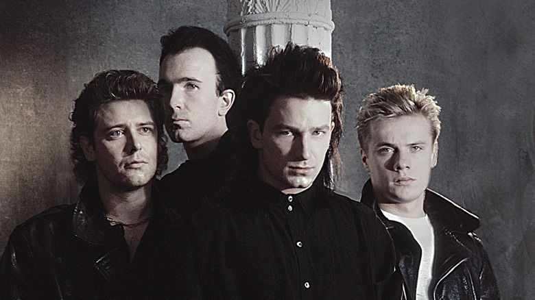 members of U2 in promo shot dressed in black