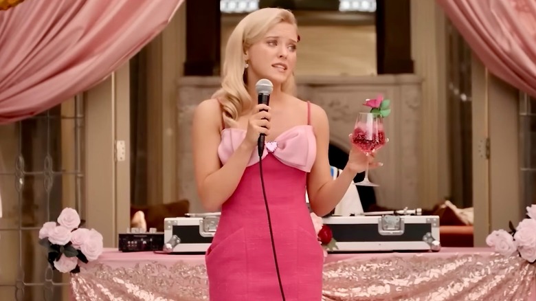 Elle giving a toast, microphone and drink in hand