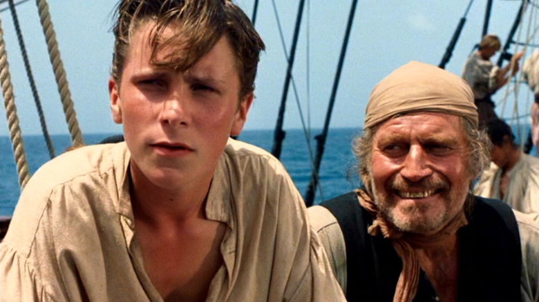 Jim Hawkins with Long John Silver behind him in Treasure Island