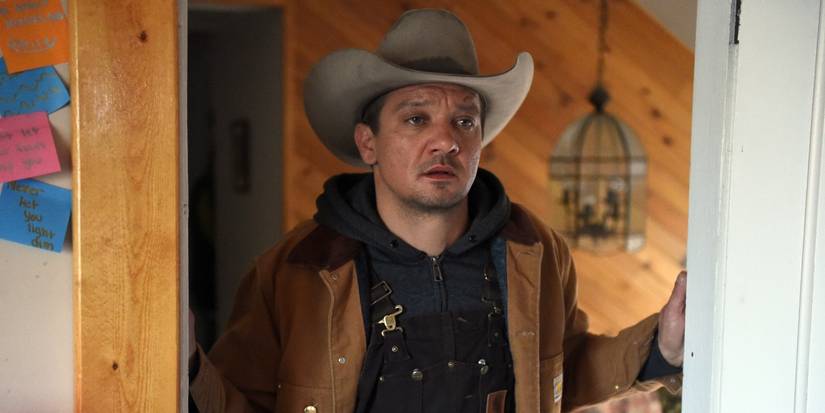 Jeremy Renner as Cole Lambert, looking in a room in a house and looking devastated in Wind River