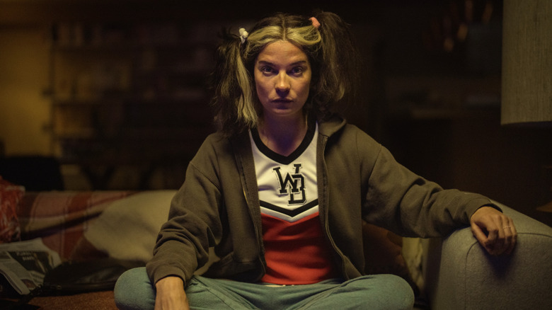 Annie Murphy's Joan Tait sitting on the couch on Black Mirror