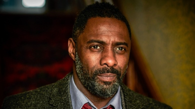 John Luther looking straight ahead while wearing his tweed overcoat in Luther Season 5