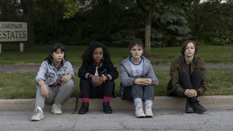 Erin, Tiffany, KJ, and Mac sitting on a curb in 