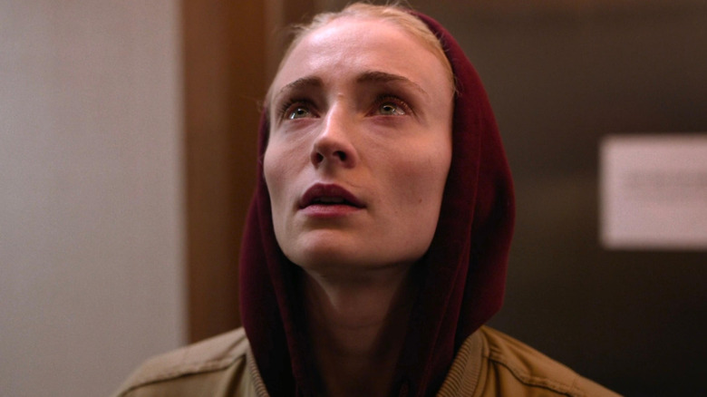 Zara wearing a hoodie and looking up
