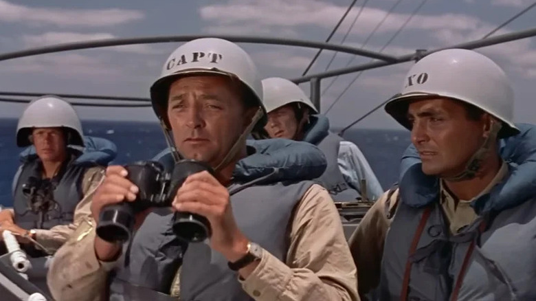 Captain Murrell holding binoculars while his men are looking on in The Enemy Below