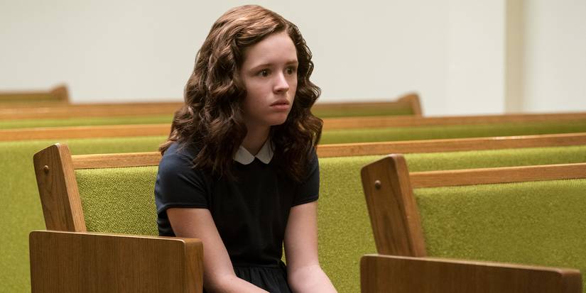 Young Shirley (Lulu Wilson) sitting in a pew with wide, frightened eyes, staring ahead.