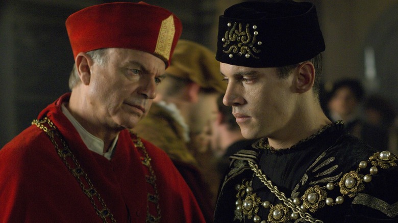 Sam Neill as Cardinal Thomas Wolsey staring at Jonathan Rhys Meyers as Henry VIII in The Tudors