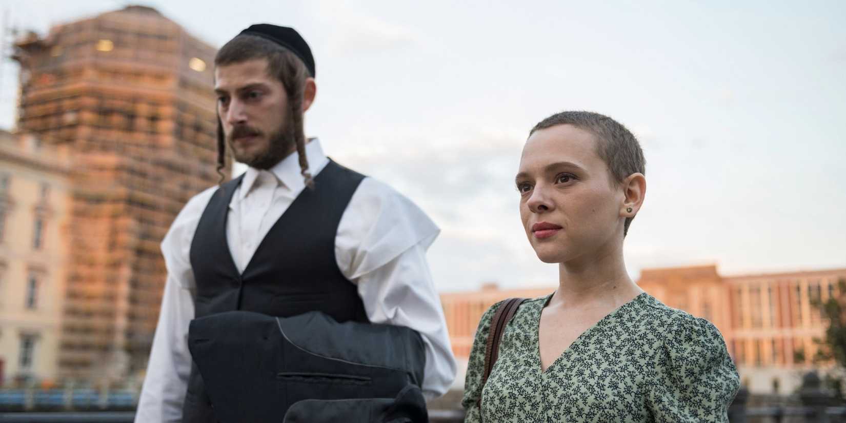 Esther Shapiro and another man walk the street in Unorthodox