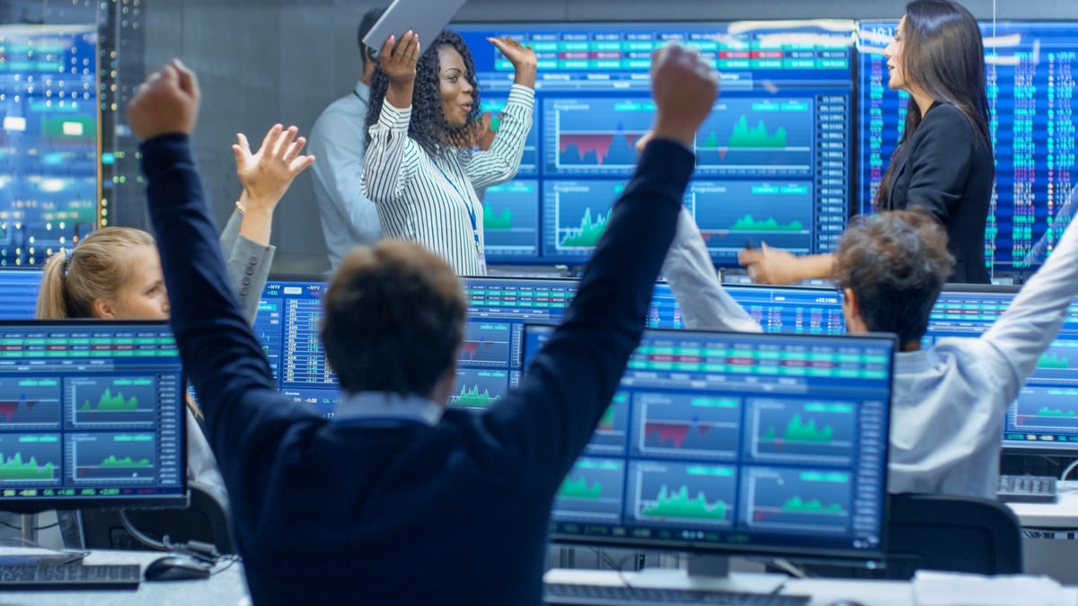 Wall Street analysts celebrating on the trading floor.