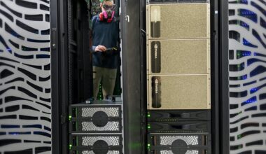 Person wearing a mask inside a data center with Nvidia chips.