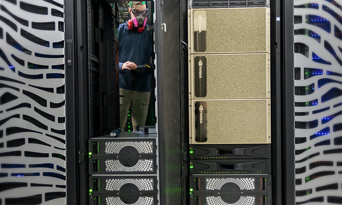Person wearing a mask inside a data center with Nvidia chips.