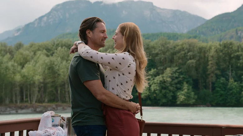 Jack Sheridan (Martin Henderson) and Mel Monroe (Alexandra Breckenridge) embrace over a scenic river in Virgin River