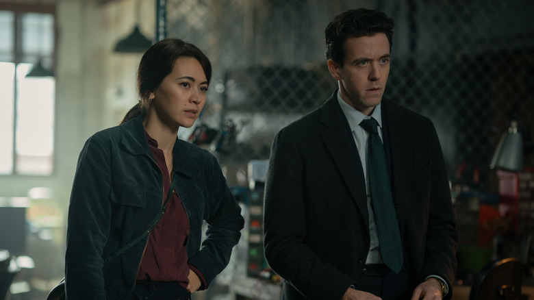 Helen Drew and Daniel Keene  looking at a potential source with skepticism in a sketchy warehouse in Silo