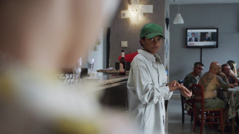 Caitlin standing in a restaurant and looking at Fraser on We Are Who We Are S1E1